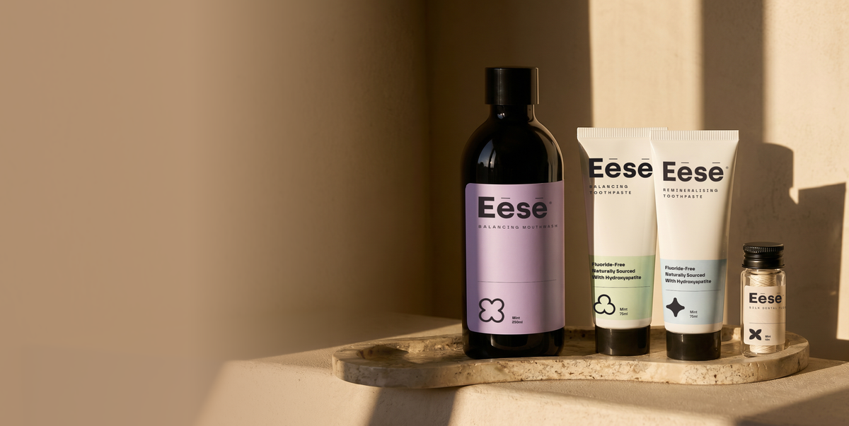 A set of Eese personal care products arranged on a stone tray, it includes a mouthwash, two toothpastes and silk floss. Four products formulated to work together, free from SLS, alcohol, and fluoride.