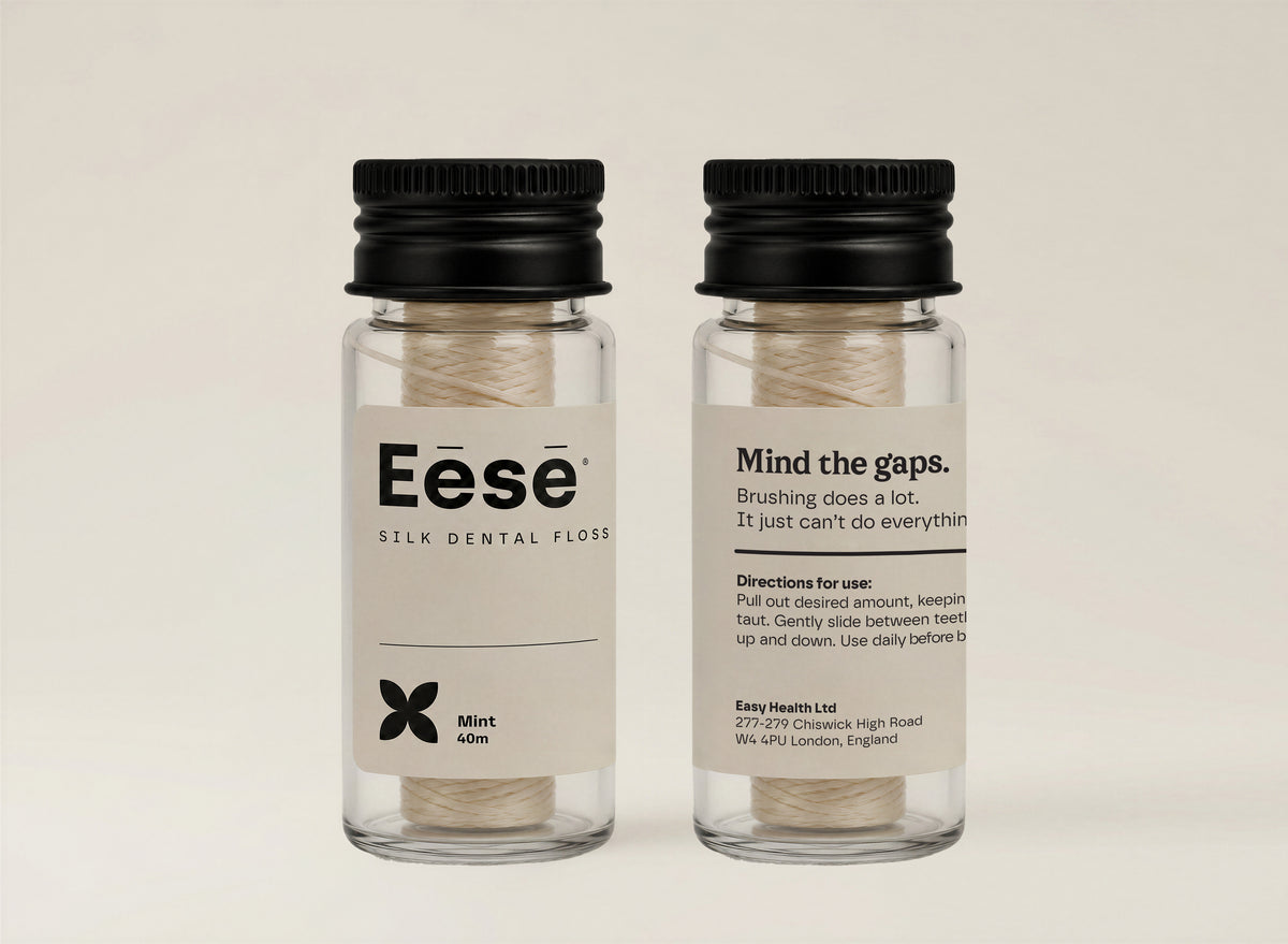 Eēsē Silk Dental Floss front and back label view in a clear glass bottle with black cap, natural mint teeth floss, 40m, on a clean cream background.