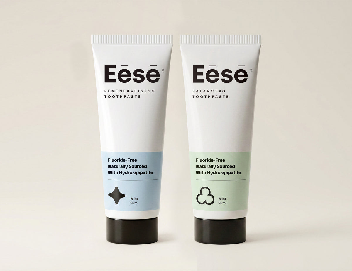 Two Eese toothpaste tubes (Balancing and Remineralising Toothpaste) standing upright on a light beige background. The left tube is labeled Mint and has a pale blue lower section, while the right tube is labeled Mint and has a pale green lower section.